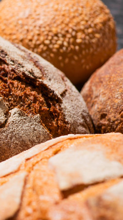 A detailed view of several freshly baked artisan bread loaves, showcasing their textured, golden brown crusts and rustic appearance.の写真素材