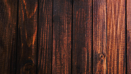 A close-up, full-frame shot of vertical dark wood planks with visible grain and subtle reddish-brown tones.の写真素材