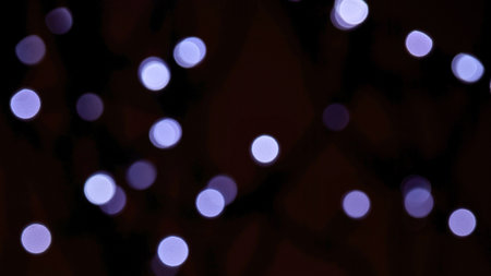 Out of focus purple lights create a dreamy, ethereal bokeh effect against a deep dark background,...