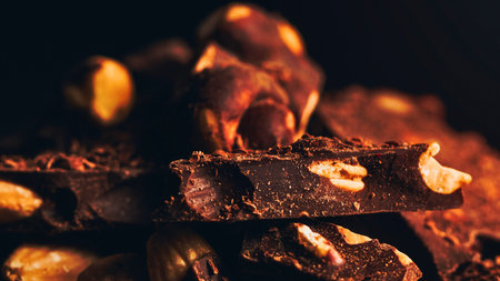 Fiery orange and red glowing embers and charred wood pieces are visible in a dimly lit fire pit.の写真素材