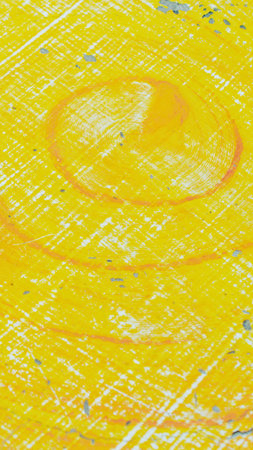 A vibrant abstract background featuring a textured surface with dominant yellow and orange hues, and faint circular shapes.の写真素材