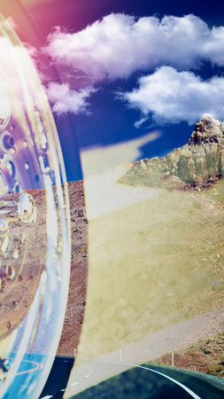 A surreal composite image showing a futuristic city within a curved glass structure, juxtaposed with a vast desert landscape and open road under a cloudy sky.の写真素材