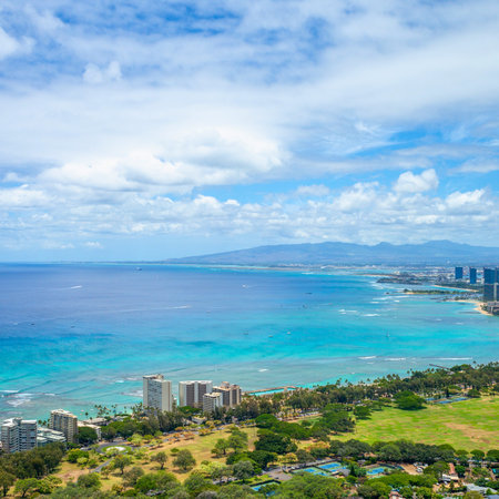 A wide shot captures a vibrant coastal city nestled beside a sparkling turquoise ocean, with a dynamic sky overhead.の写真素材