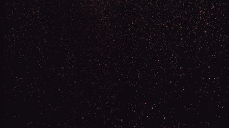 A deep black background with a subtle, scattered pattern of tiny red and dark pink speckles creating a textured effect.の写真素材