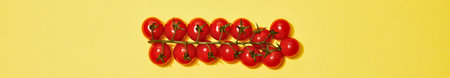 A group of shiny red clothespins are bundled together with a string against a bright, solid yellow backdrop.の写真素材