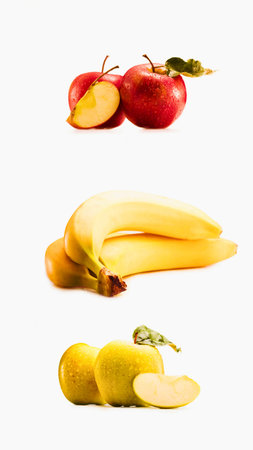 A studio shot of three distinct rows of fruit: sliced apples, a bunch of bananas, and sliced lemons against a white background.の写真素材