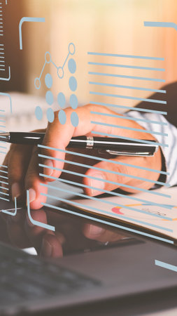 A person's hands are shown touching a screen displaying abstract data and futuristic graphics, suggesting technology and analysis.の写真素材