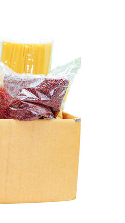 A close-up shot of a cardboard box filled with fresh ingredients, including red produce and yellow items, ready for meal preparation.の写真素材