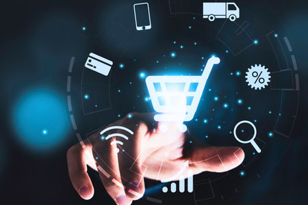 A hand reaches out, interacting with a glowing digital shopping cart surrounded by various e-commerce icons and data visualizations.の写真素材
