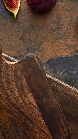 A close-up, artistic shot featuring a sliced fig and dark grapes against a richly textured, abstract background.の写真素材