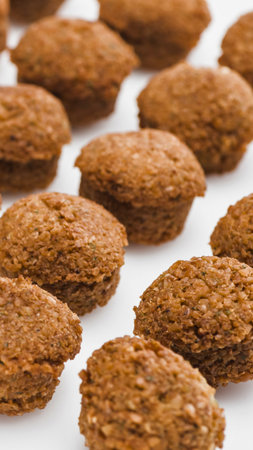 A close-up shot showcases a generous spread of freshly baked falafel. The golden-brown spheres are arranged on a clean white surface, highlighting their texture.の写真素材