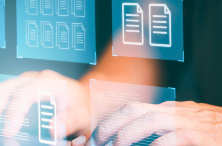 Blurred hands are typing on a keyboard, with glowing blue digital document icons appearing around them.の写真素材