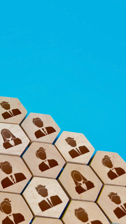 A close-up, angled view of hexagonal tiles, each featuring a silhouette of a person, arranged in a honeycomb pattern on a vibrant blue surface.の写真素材