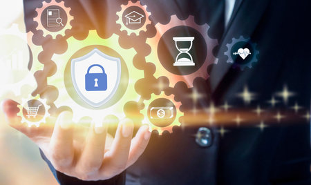 A person's hand holds glowing icons representing security, time, and business processes, suggesting digital transformation and data protection.の写真素材