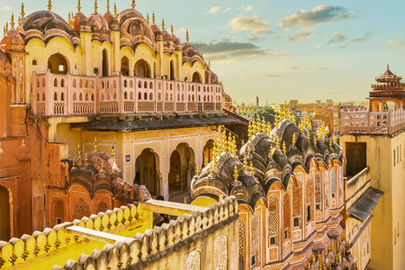 A detailed view of a grand pink palace with ornate windows and balconies, set against a soft, cloudy sky.の写真素材