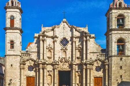 The ornate facade of the Havana Cathedral stands majestically against a clear blue sky, showcasing its intricate architecture and twin bell towers.の写真素材