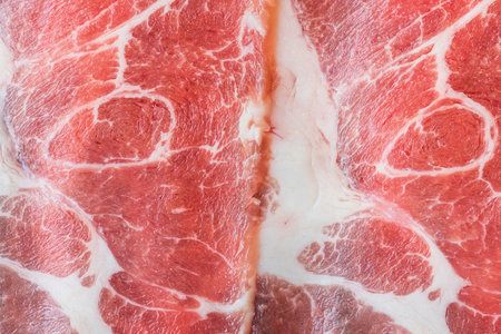 Detailed view of raw beef slices showing prominent white fat marbling throughout the red meat.の写真素材