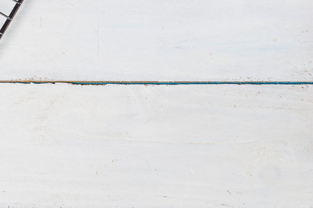 A stark, minimalist image featuring a thin black branch with a subtle shadow against a bright white background.の写真素材