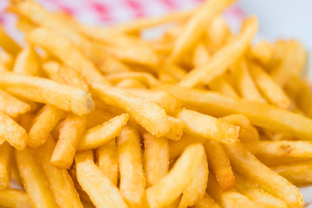 A close-up, slightly blurred view of a generous pile of perfectly fried, golden brown french fries.の写真素材