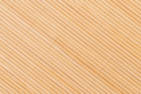 A detailed view of a light brown woven material featuring a repeating pattern of diagonal ridges and subtle color variations.の写真素材
