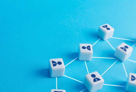 Small white cubes with person icons are connected by thin white lines on a vibrant blue background, symbolizing a network.の写真素材