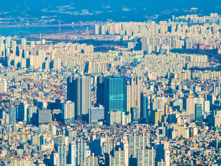 An aerial view of a sprawling city with countless high-rise buildings packed closely together under a bright sky.の写真素材