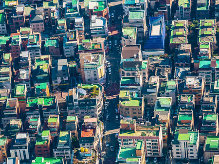 An abstract, high-angle view of a densely packed city, showcasing a mosaic of buildings, rooftops, and winding streets below.の写真素材