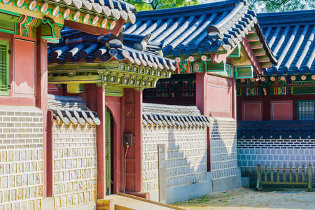 A close-up view of a traditional Korean palace wall and roof, showcasing vibrant colors and intricate architectural details.の写真素材