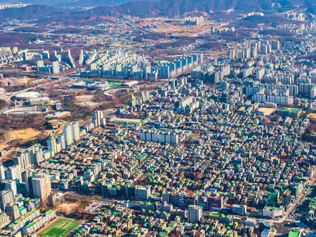 An extensive aerial perspective showcases a sprawling urban environment filled with numerous residential and commercial buildings under a clear sky.の写真素材