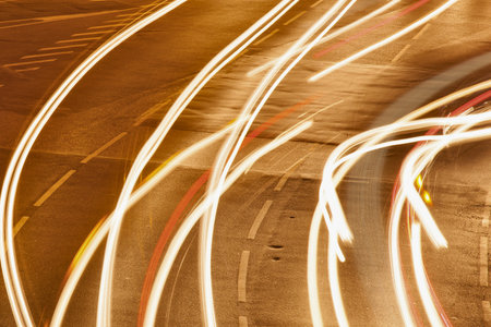 Abstract streaks of warm light create a dynamic pattern across a textured surface, suggesting movement and energy.の写真素材