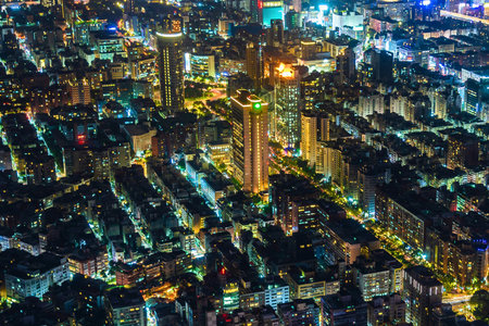 An aerial view of a dense urban area at night, with buildings and streets glowing in a kaleidoscope of colorful lights.の写真素材