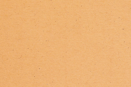 A soft, gradient background transitioning from a light peach to a muted orange with a subtle speckled texture.の写真素材