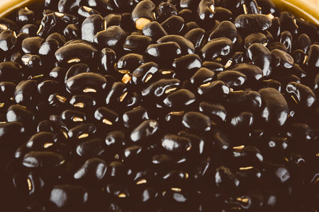 A tightly packed, high-angle view of glossy black beans, showcasing their smooth texture and deep color.の写真素材
