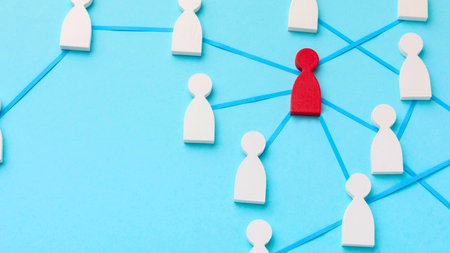 A red figure stands out within a network of connected white figures, symbolizing a central point or outlier in a system.の写真素材