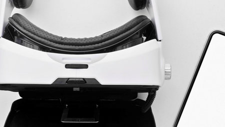 A white robot with a distinctive smiling face is shown next to a blank screen, suggesting interaction or display.の写真素材