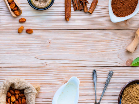 A top-down view of various spices, seeds, and grains arranged on a weathered wooden table, creating a border with a central empty space.の写真素材