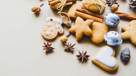 A charming arrangement of gingerbread cookies, cinnamon sticks, star anise, and jingle bells evokes...