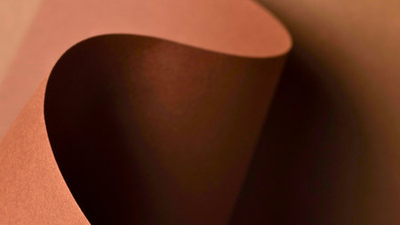 A close-up abstract view of flowing curves and deep shadows in warm, earthy tones, creating a sense of depth and texture.の写真素材