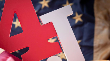Close-up of red and white cutout letters spelling 'JULY' with a blurred American flag in the background, suggesting patriotic celebration.の写真素材
