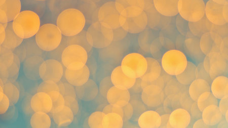 Abstract bokeh effect with warm golden circles of light scattered across a muted, textured background in shades of blue and beige.の写真素材