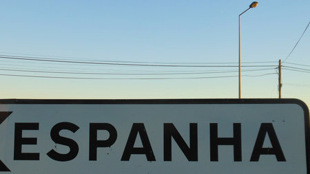 A close-up of a white sign with the word ESPANHA in large black letters, against a clear sky with a streetlight.の写真素材