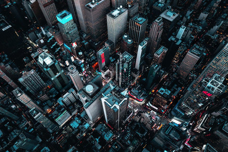 An aerial shot showing a lively city with illuminated skyscrapers at night.