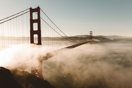 A peaceful scene of the Golden Gate Bridge with fog during sunset with colorful sky