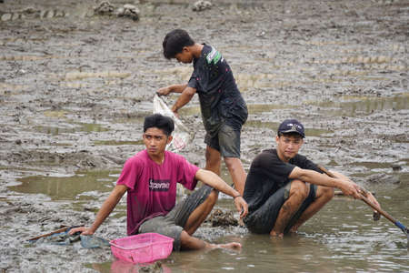 People fishing on gropyok iwak. Gropyok iwak means festival fishing together using traditional toolsのeditorial素材