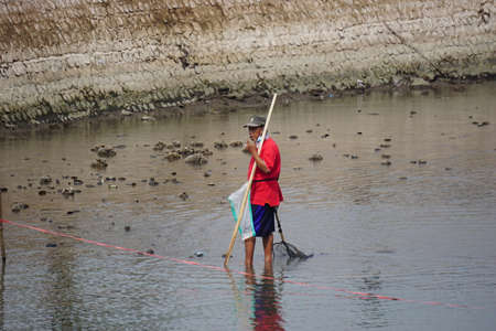 People fishing on gropyok iwak. Gropyok iwak means festival fishing together using traditional toolsのeditorial素材