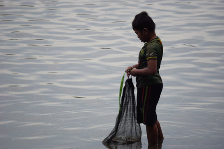 People fishing on gropyok iwak. Gropyok iwak means festival fishing together using traditional toolsのeditorial素材