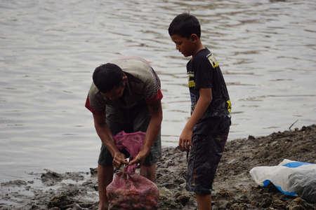 People fishing on gropyok iwak. Gropyok iwak means festival fishing together using traditional toolsのeditorial素材