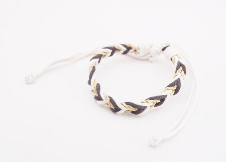 An isolated ethnic bracelet on white background. The bracelet is made off the various ropeの写真素材