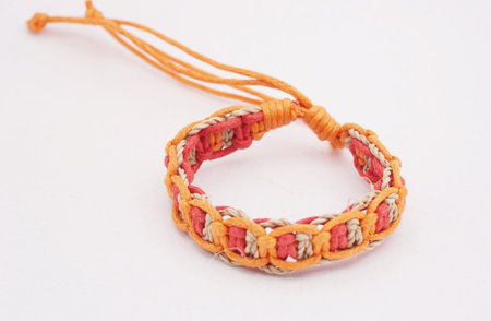 An isolated ethnic bracelet on white background. The bracelet is made off the various ropeの写真素材