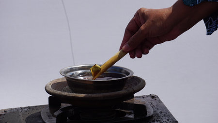 The wax (Indonesian call it malam) melts in the pan. This wax is used in the process of making batik clothの写真素材